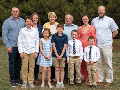 Cathy Logue and family posing for photo in front of trees